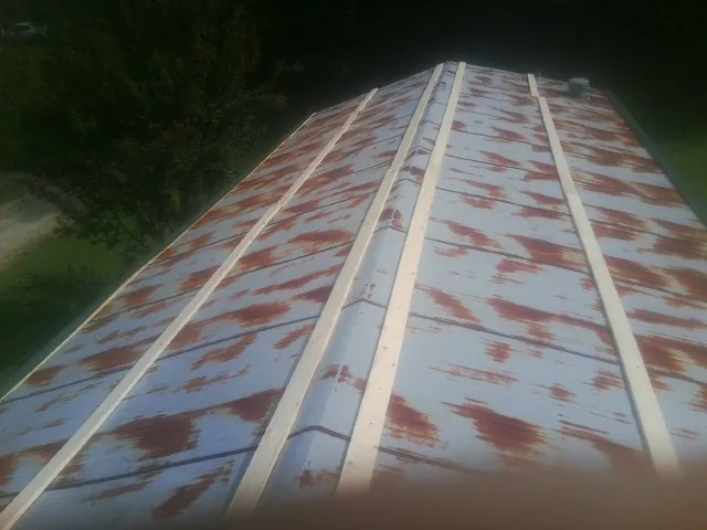 Rusted metal roof panels with new wood purlins before replacement — Storm Damage Roof Repair in Jackson by Roofing Brothers